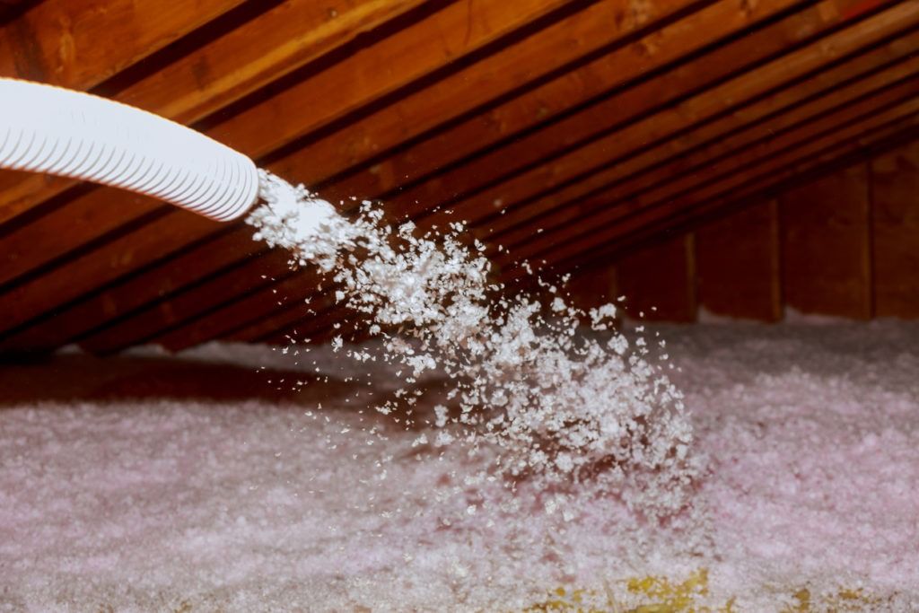 Soufflage de ouate de cellulose pour une isolation thermique performante, améliorant l'efficacité énergétique du bâtiment.