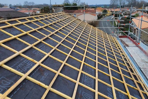 Rénovation de toiture en cours avec la mise en place d'une nouvelle structure en liteaux, améliorant l'isolation et la durabilité.