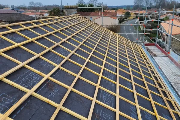 Rénovation de toiture en cours avec la mise en place d'une nouvelle structure en liteaux, améliorant l'isolation et la durabilité.